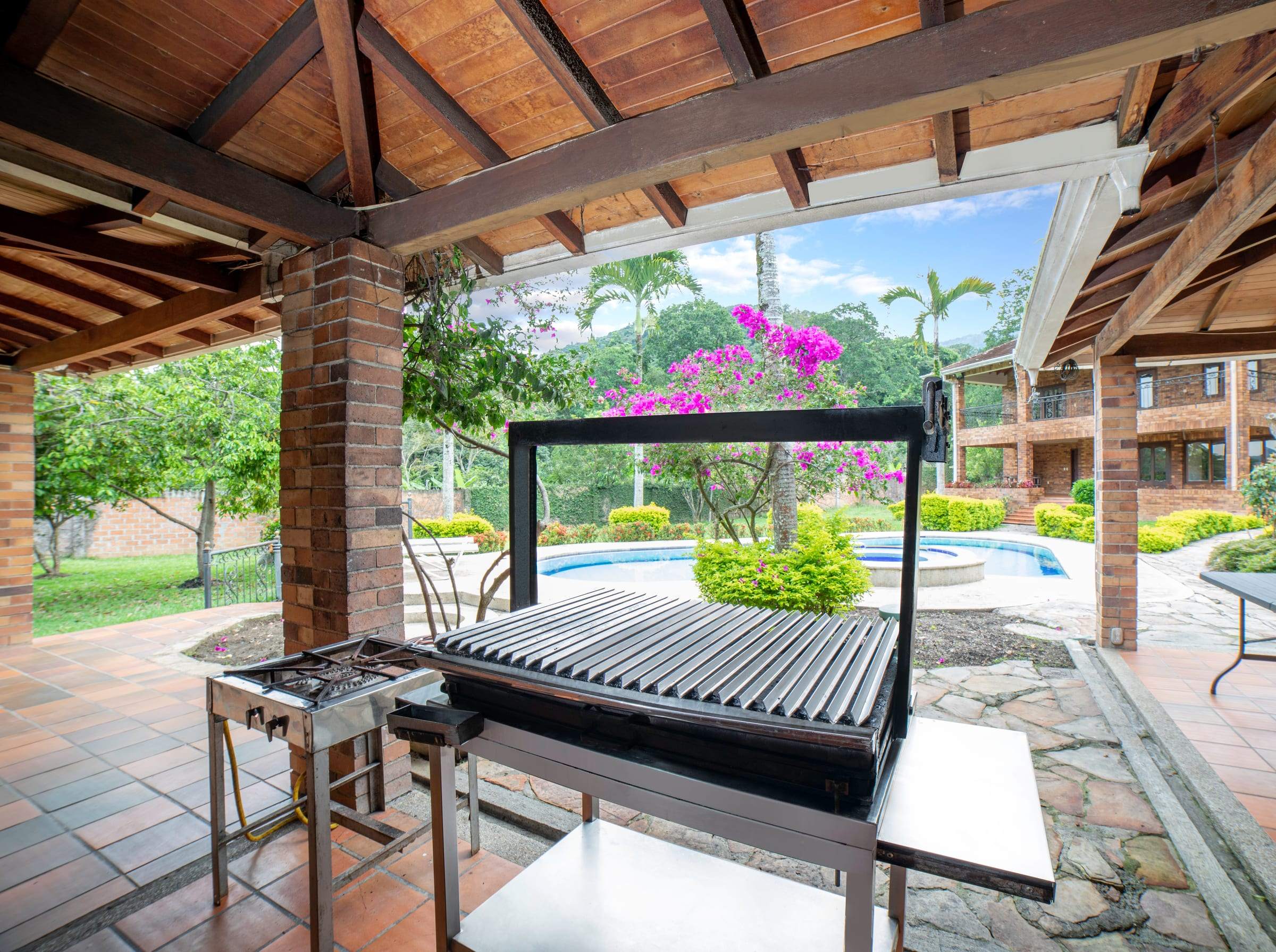 Asador a carbón frente a la piscina